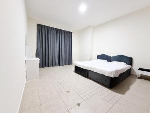 a white bedroom with a bed and a window at Rose Building in Dubai