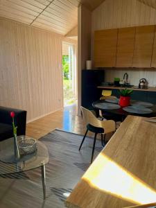a room with tables and chairs in a kitchen at Nowa Pasłęka - Domki Passarge in Braniewo +6 photos