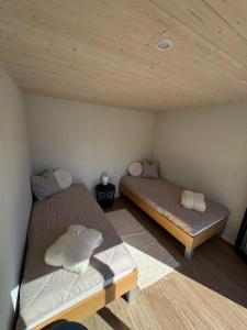 a room with two beds and a wooden ceiling at Nowa Pasłęka - Domki Passarge in Braniewo