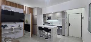a kitchen with a sink and a counter with stools at Roca Madryn in Puerto Madryn