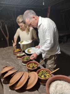 a man and a woman preparing food in bowls at Clay Hut by Ever Green Eco Resort in Wilpattu +21 photos