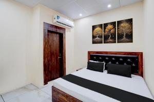 a bedroom with a large bed with a wooden headboard at Hotel O Star Light in Rohtak