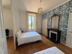 a bedroom with a bed and a mirror and a fireplace at Château Saint Georges in Mauléon