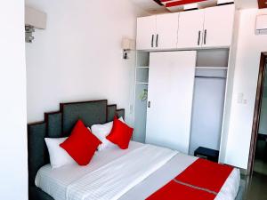 a bedroom with a bed with red pillows at Comfort Deluxe Apart in Kigali