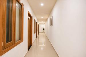 a corridor with white walls and a long hallway at Collection O Guru Nanak Dev University Amritsar Formerly Hotel Tashi in Amritsar