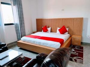 a bedroom with a large bed with red pillows at Comfort Deluxe Apart in Kigali