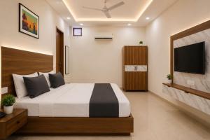 a bedroom with a large bed and a flat screen tv at Collection O Guru Nanak Dev University Amritsar Formerly Hotel Tashi in Amritsar