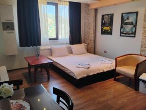 a small room with a bed and a table at STADIUM 2 Apartments Sandanski in Sandanski
