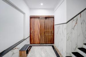 a wooden door in a white room with a staircase at Hotel O India Expo Mart Noida Formerly Xponest in Greater Noida