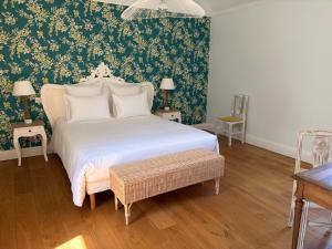 a bedroom with a white bed with floral wallpaper at Château Saint Georges in Mauléon
