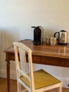 a wooden table with a coffee maker and a toaster at Château Saint Georges in Mauléon