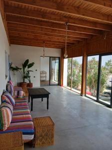 a living room with a couch and a table at Dar Isma : Une maison sur océan in Wassane