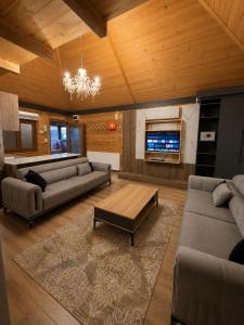 a living room with two couches and a tv at Beş Evler Apart in Uzungöl