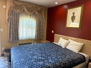 a bedroom with a bed and a window at Penguin Motel in Harbor City