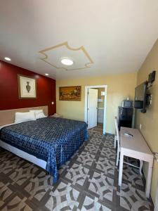 a bedroom with a bed and a table and a desk at Penguin Motel in Harbor City
