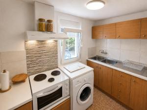 a kitchen with a washing machine and a sink at Rou Garden House in Karpathos