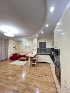 a kitchen and living room with a table and a couch at Casa Trio in Tirana