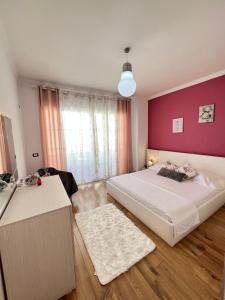 a bedroom with two beds and a pink wall at Casa Trio in Tirana