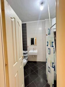 a bathroom with a white toilet and a sink at Casa Trio in Tirana +14 photos