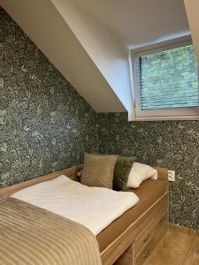 a small bed in a bedroom with a window at Apartmán vinařství U Krčků in Zaječí