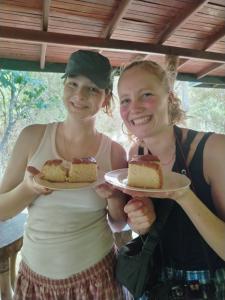 two girls holding two slices of cake on a plate at Clay Hut by Ever Green Eco Resort in Wilpattu