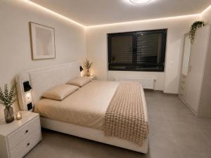 a white bedroom with a large bed and a window at The Eight in Luxembourg