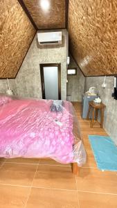 a bedroom with a pink bed in a room at บ้านสวนแม่จันทร์เพ็ญ in Chiang Dao