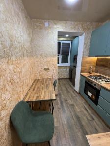 a kitchen with a wooden table and a green chair at Apartment in Jvari in Jvari