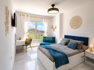 ein Schlafzimmer mit Bett, Schreibtisch und Fenster in der Unterkunft Lanja Suites in Lanjarón