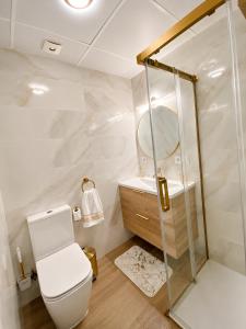 ein Badezimmer mit Toilette und Spiegel in der Unterkunft Lanja Suites in Lanjarón