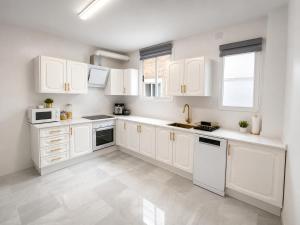 Eine weiße Küche mit weißen Schränken und weißen Geräten in der Unterkunft Lanja Suites in Lanjarón