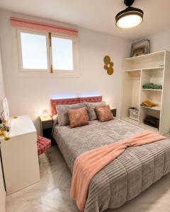 ein Schlafzimmer mit Bett, Schreibtisch und zwei Fenstern in der Unterkunft Lanja Suites in Lanjarón
