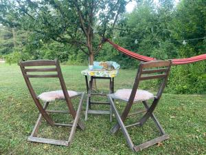 two chairs sitting next to a table and a hammock at River & Forest Escape, Private Garden Room near Ljubljana in Preddvor
