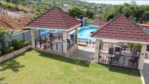 a house with a gazebo and a swimming pool at Snl Mountain View Hotel in Oko Sombo