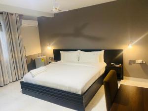 a bedroom with a large bed and a chair at Snl Mountain View Hotel in Oko Sombo +14 photos