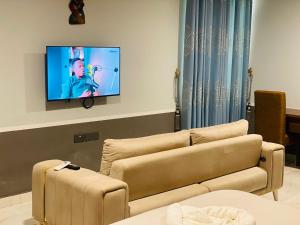 a living room with a couch and a flat screen tv at Snl Mountain View Hotel in Oko Sombo