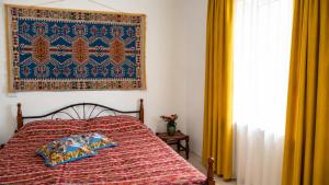 a bedroom with a bed with a red comforter at Guest House in Sanahin in Sanain