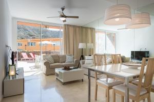 ein Wohnzimmer mit Tisch und ein Esszimmer in der Unterkunft Ilusión in La Playa de Tauro