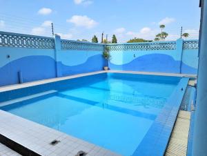 a swimming pool with blue tiles on a fence at Terry's 2br sunsweet resort shanzu,mombasa in Mombasa