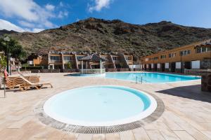 ein großer Pool mit einem Berg im Hintergrund in der Unterkunft Ilusión in La Playa de Tauro