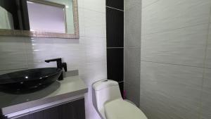 a bathroom with a black sink and a toilet at Pent House La Castellana in Armenia +19 photos
