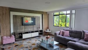 a living room with a couch and a tv at Pent House La Castellana in Armenia