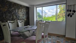 a dining room with a table and chairs and a window at Pent House La Castellana in Armenia
