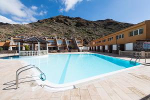 una piscina en un hotel con una montaña en el fondo en Ilusión, en La Playa de Tauro