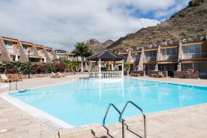 ein Pool in einem Resort mit einem Berg im Hintergrund in der Unterkunft Ilusión in La Playa de Tauro