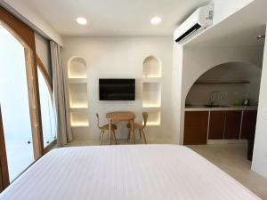 a bedroom with a white bed and a table at Namal Resort - Free scooter and Gym access in El Nido