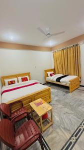 a bedroom with two beds and a table and chairs at Kaka G Hotel Utror Valley in Utrot +35 photos