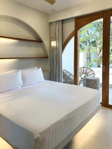 a bedroom with a bed and a balcony at Namal Resort - Free scooter and Gym access in El Nido +43 photos