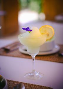 a drink in a glass with a purple flower in it at Namal Resort - Free scooter and Gym access in El Nido