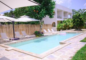 a swimming pool with chairs and umbrellas next to a house at Namal Resort - Free scooter and Gym access in El Nido